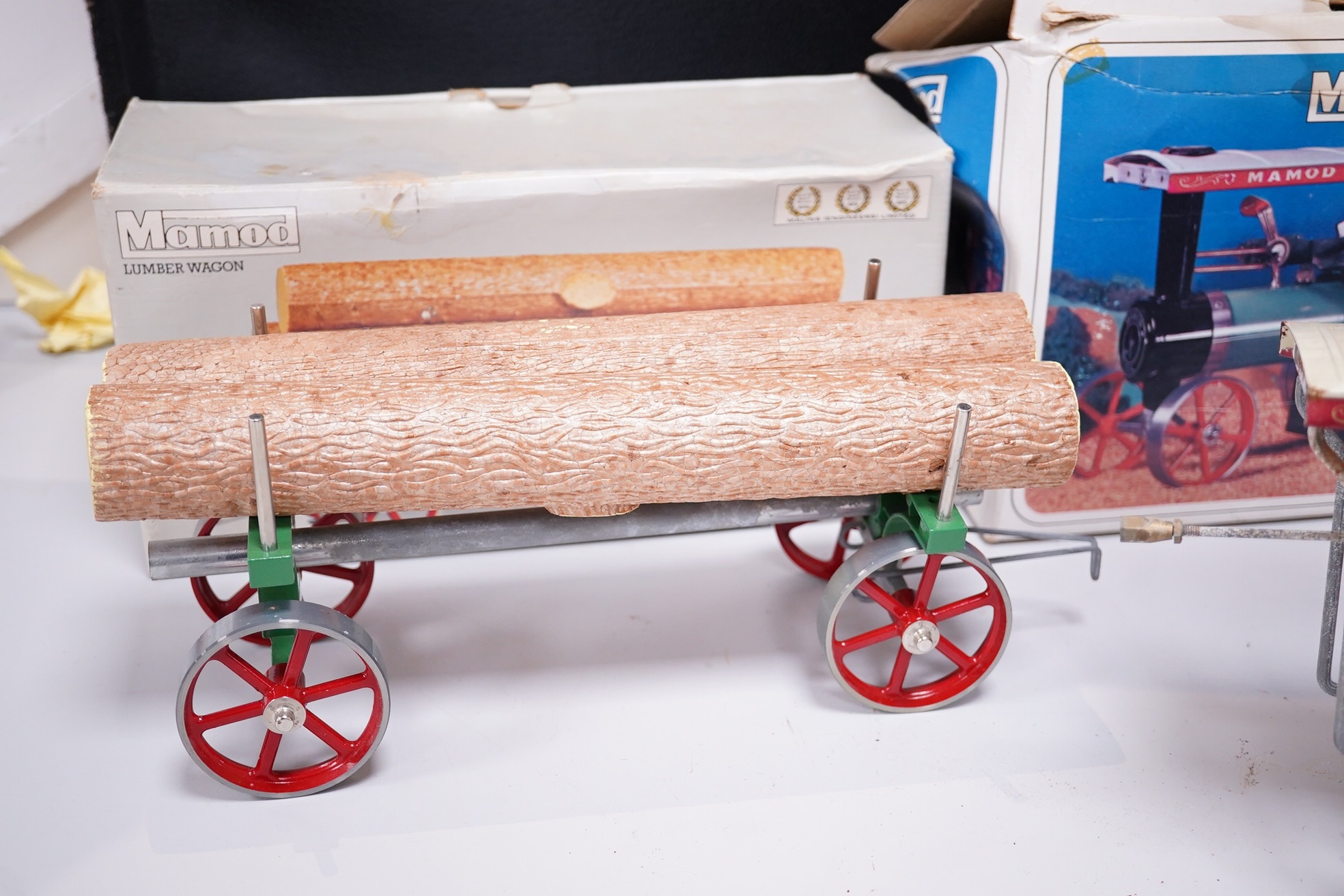 A boxed Mamod TE-1A live steam traction engine and lumber wagon. Condition - poor to fair, there is corrosion to the exposed aluminium and other metal parts.